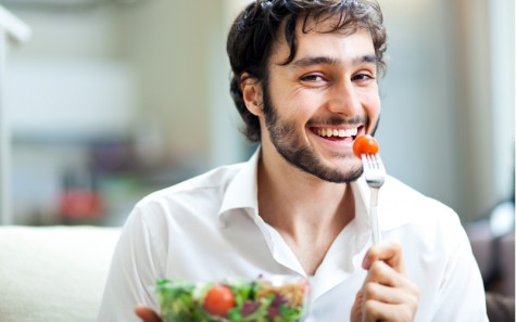 Happy man eating a salad
