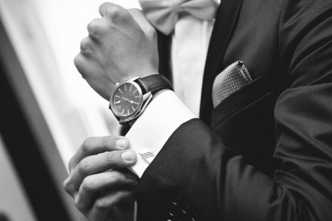Close up of elegant man in suit with watch on hand