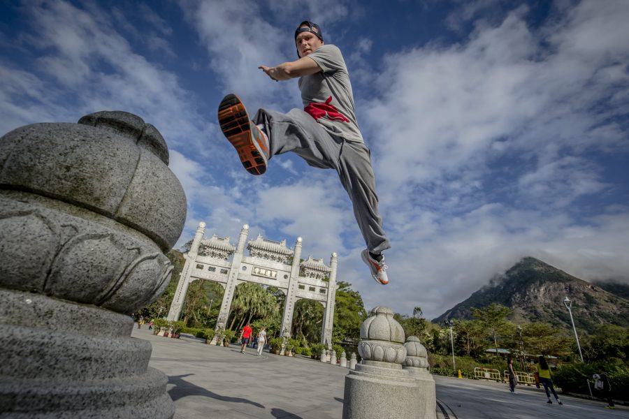 Parkour hoàn toàn không phải trò chơi mạo hiểm, người mặc đồ xám nhảy giữa 2 bục đá.