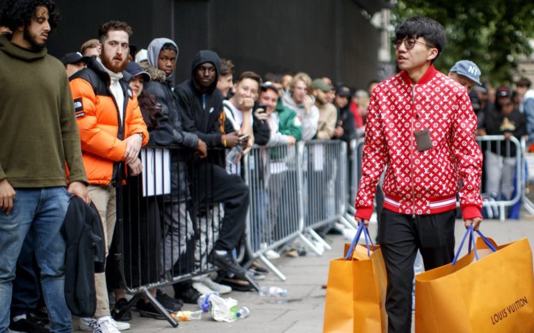 Jae Sung - A man walks away with his purchases as people queue for Louis Vuitton special edition sale on the Strand in central London on June 30, 2017. Picture credit: Tolga Akmen