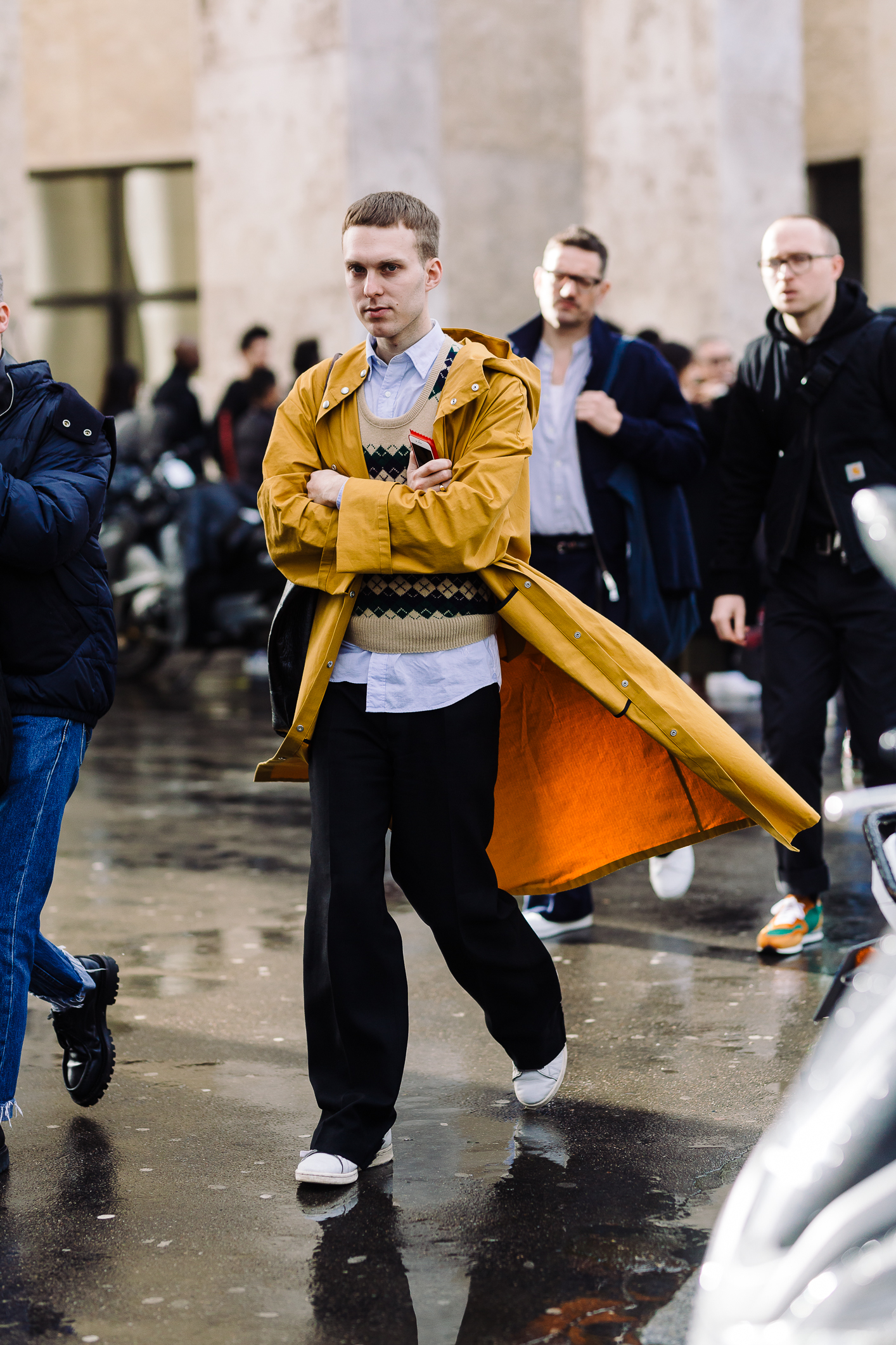 Aó khoác trench coat màu vàng đậm bên ngoài kết hợp áo len và sơ mi xanh nhạt bên trong, tạo nên những mảng màu tươi sáng cho những ngày mưa ảm đạm ở Paris