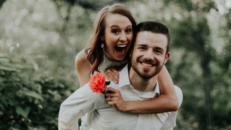 tính cách nam cự giải khi yêu - chàng trai cõng cô gái cầm đóa hoa