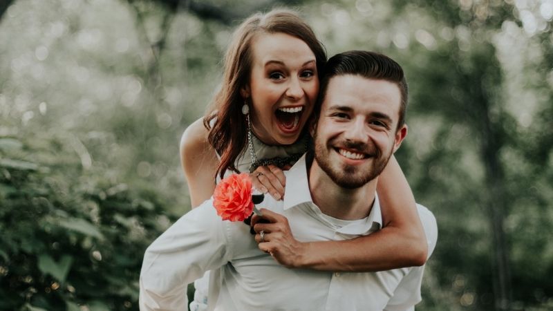 tính cách nam cự giải khi yêu - chàng trai cõng cô gái cầm đóa hoa