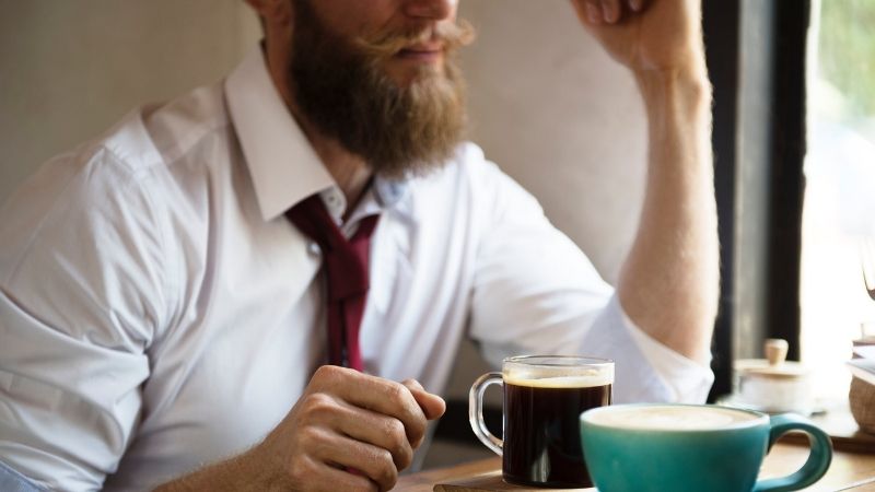 tac hai cua caffeine - nguoi dan ong mac so mi trang ngoi lam viec voi tach tra tren ban - elle man feature
