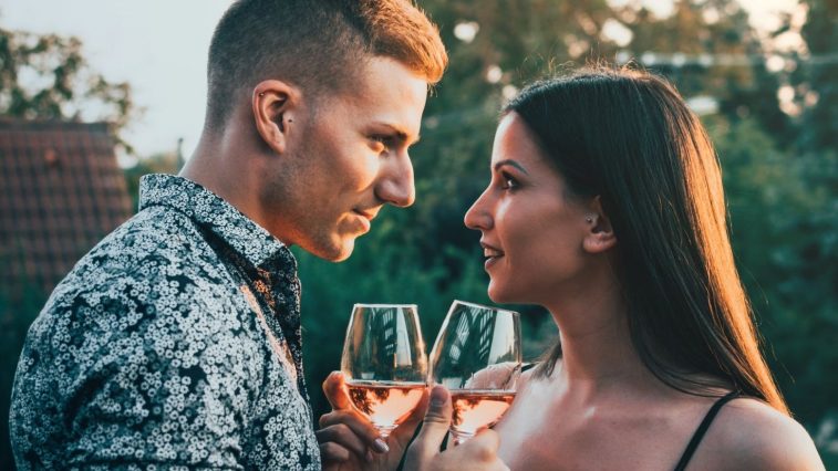 tính cách đàn ông sư tử khi yêu - chàng trai cầm ly rượu nhìn vào mắt cô gái